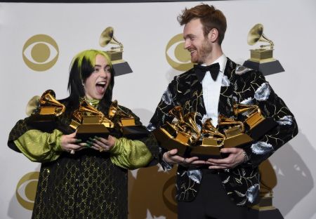 billie and brother Finneas holding 5 grammys each 